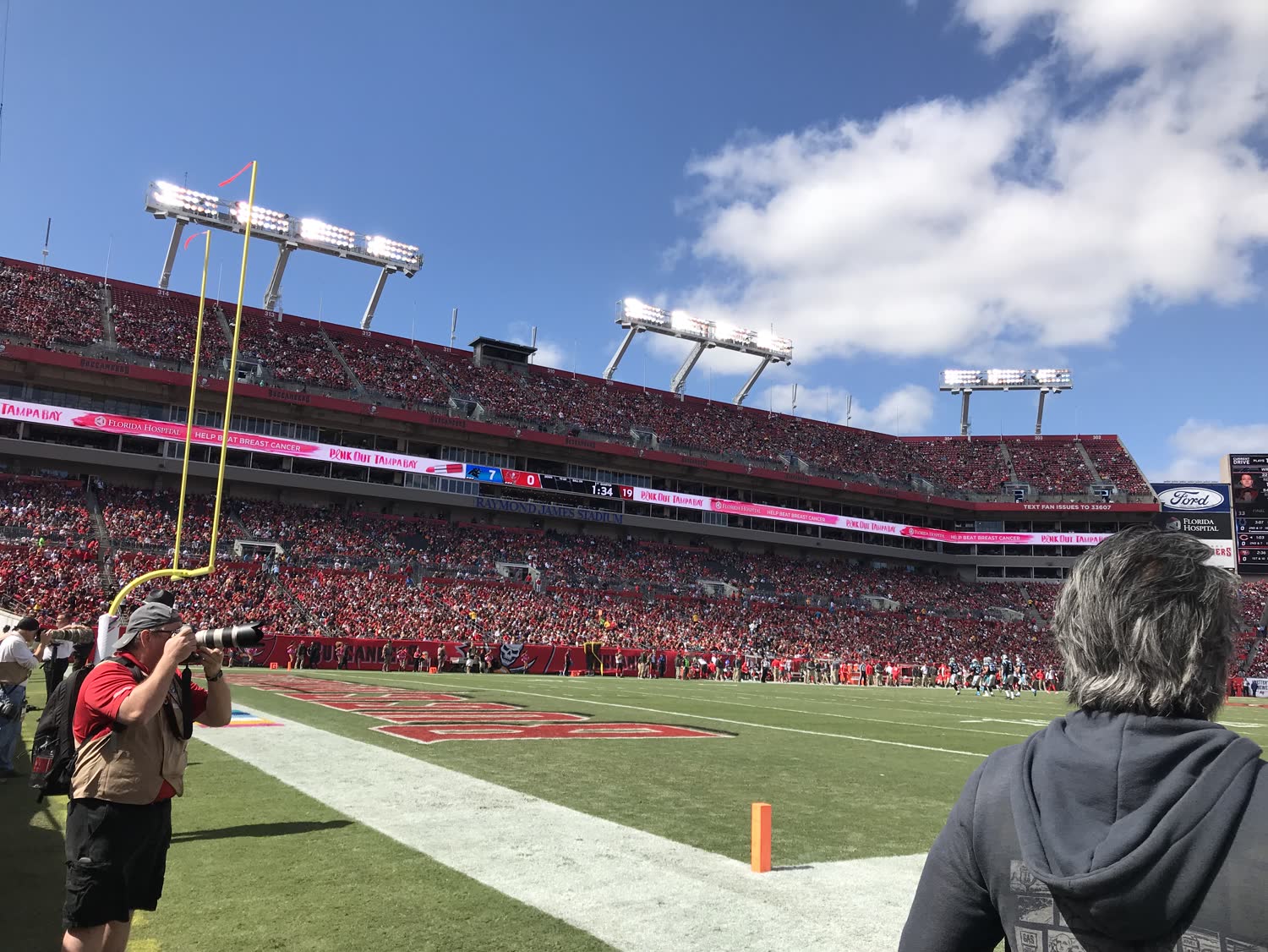 Wilson on the sideline at Raymond James Stadium during a Buccaneers game, beside a team photographer